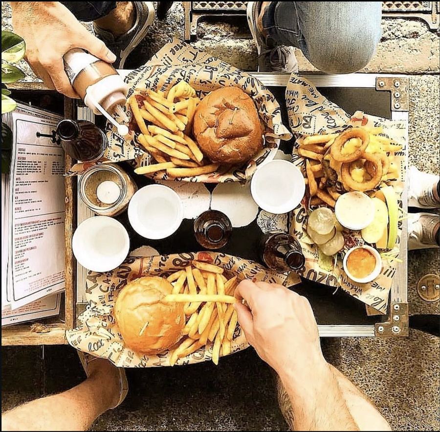 Burgers and fries on a road-case table in the sun